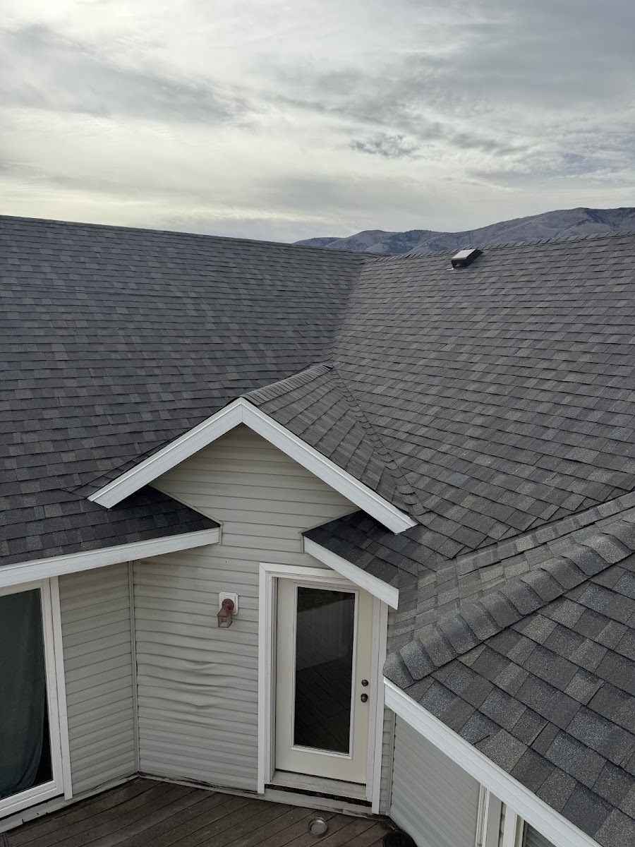 Completed gray shingle roof with mountains in background